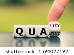 Quality over quantity. Hand turns a dice and changes the word "quantity" to "quality".