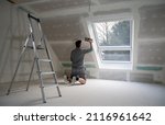Man Plastering Drywall In A...