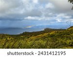 Small photo of A rainbow over the west coast of Guam with intermittent rain squalls.
