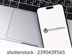 Small photo of WordPress logo mobile app on a screen smartphone iPhone with Macbook background. WordPress - open source site content management system. Batumi, Georgia - October 28, 2023