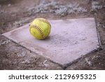 A Yellow Softball Rests On A...