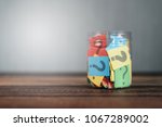 colorful paper with question mark in a plastic jar on wooden table. questions and diversity concept. FAQ and Q&A background concept