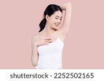 Small photo of Beautiful young Asian woman lifting hand up to shows off clean and clear armpit or underarms isolated on pink background, Smooth and freshness armpit concept.
