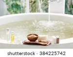 Spa decoration, natural organic products on a bathtube. Loofah, towel and frangipani flower