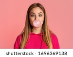 Bubble from chewing gum. Teenage girl on pink background