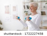 Gym At Home. Positive Aged Woman Training With Dumbbells In Living Room, Copy Space