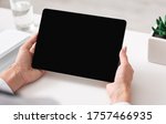 Small photo of Watching video lesson or online webinar. Woman hands holds ablet with blank screen on white table with notepad, plant and glass of water