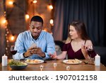 Small photo of Phubbing Concept. Black Man Busy With Smartphone During Romantic Dinner With His Girlfriend, Annoyed Young Woman Looking At Boyfriend With Reproach, Multiracial Couple Having Relationship Problems