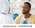 Black guy receiving nasal PCR test while staying home