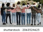 Small photo of Back view of multiracial millennial demonstrators in casual standing in a row on the street, embracing, making live chain, fighting fot human rights, defying lockdown restrictions, panorama