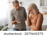 Small photo of Family Quarrel. Angry Mature Husband Shouting At Unhappy Wife Having Conflict Standing At Home. Marital Problems, Domestic Abuse And Violence, Marital Crisis Concept