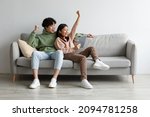 Small photo of Excited young Asian couple sitting on couch with tablet pc, celebrating online win, great deal or business success at home, free space. Millennial spouses enjoying big sale in web store