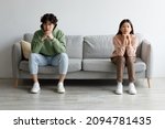 Small photo of Family conflict, divorce, breakup concept. Stubborn young Asian couple sitting on opposite sides of couch in silence after fight, indoors. Offended millennial man and woman ignoring one another