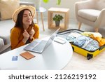 Small photo of Overjoyed young woman booking hot tour online, excited over huge sale in tourist agency, using laptop to book hotel or buy plane tickets on discount from home, free space. Abroad travel concept