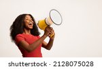 Small photo of Great Promo. Excited Black Lady Using Megaphone For Making Announcement, Cheerful African American Woman Holding Loudspeaker, Sharing News While Standing On White Background, Panorama, Copy space