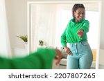 Small photo of Self confident black woman pointing finger at her reflection in mirror, dancing and felling good, enjoying good mood. Independent lady with high self esteem talks positive and I can do it motivation.
