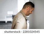 Upset middle aged businessman banging his head against wall in despair looking stressed, having problems at work. Business failure, unsuccessful negotiations, failed job interview concept