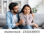 Compassionate eastern husband giving comfort, support to upset wife, holding shoulders, speaking expressing empathy. Man feeling guilty, asking girlfriend to forgive. Relationship, compassion concept