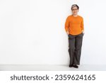 Small photo of Happy beautiful stylish short-haired mature woman wearing casual outfit and eyeglasses posing with hands in pockets isolated on white background, copy space, full length. Boomers lifestyle