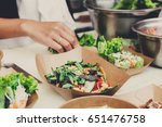 Street food festival, catering service. Vegetable salads in kraft paper plates sold outdoors at local market place, shallow depth of field