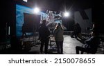 Small photo of Behind the scenes of virtual production shot - Film crew working with Caucasian female astronaut stuntwoman in a spacesuit hanging on a wires against huge LED screen. Some elements furnished by NASA