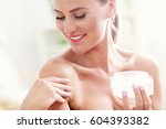 Picture of a fit woman holding lotion over her body