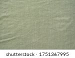 Crumpled linen textile fabric of khaki color as background, top view