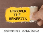 Hand of man tearing paper revealing the text Uncover the Benefits.