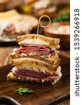 Small photo of Ruben sandwich. New York sandwich with pastrami, sauce 1000 islands and sauerkraut. Front view. Fast food.