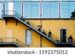 Small photo of Lisbon, Portugal - Sept 28, 2018: Workers in uniform check their smartphones and enjoy a cigarette break on a classical fire emegency stairs in Lisbon, Portugal