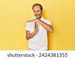 Small photo of Caucasian middle-aged man in yellow studio showing a timeout gesture.