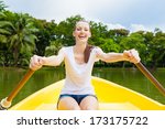 Happy young woman enjoying rowing boat ride on the lake