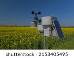 Smart agriculture and smart farm technology. Meteorological instrument used to measure the wind speed and solar cell system in the raps field. Weather station with solar panel placed in the field.