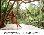 Tourist woman swing on wicker rattan hang chair in the jungle, nature view