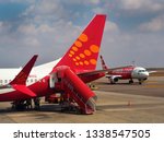 Small photo of HYDERABAD, ANDHRA PRADESH, INDIA, MARCH 02, 2019: Tail end of a SpiceJet airline with ladder in the foreground, and an AirAsia jet in the background, on the tarmac on a sunny day.