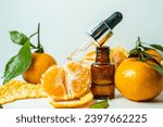 Small photo of Fragrant tangerine oil with tangerines on a white background. Bottles of citrus essential oil and sliced fruits on a white background. selective focus.