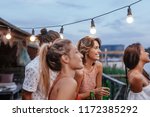 Group of beautiful women and man standing on terrace and enjoying summer vacation.