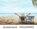 Summer beach travel vacation concept, Happy traveler asian woman with hat relax on chair beach at Pattaya, Chon Buri, Thailand