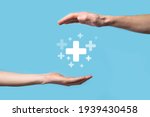 Male hand holding plus icon on blue background. Plus sign virtual means to offer positive thing (like benefits, personal development, social network)Profit,health insurance, growth concepts.