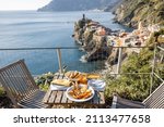 Served lunch table with seafood on coast at Vernazza village in Italy. Concept of mediterranean seafood and summer vacations