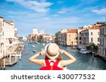 View on Grand canal with woman traveler in hat on Academia bridge in Venice. Back view with copy space