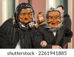Small photo of Masked old couple at Pust 2023 carnival parade, San Pietro al Natisone, Udine province, Friuli Venezia Giulia, Italy. Masks from Fornesighe, Val di Zoldo, Belluno. La Gnaga tradition.
