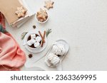 Aesthetic Christmas background with cup of cocoa, marshmallows, ginger snowflakes cookies, cinnamon sticks and books at cozy home flat lay. Copy space.