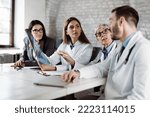 Group of doctors analyzing medical scan with businesswoman  in the hospital