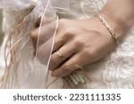 bride with a modern gold bracelet, wedding ring and solitaire ring on her wrist,  holding elegant modern autumn wedding bouquet.The concept of lifestyle and autumn wedding