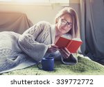 pretty girl reading book with coffee lying in bed