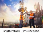 Small photo of Architect and engineer construction workers shaking hands while working at outdoors construction site. Building construction collaboration concept