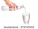 Woman's hand holding a bottle of water Pouring water into a glass