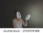 Small photo of woman with mask chooses another mask of herself, the concept of introspection