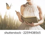 Small photo of surreal encounter in a meadow between a woman reading a book and a butterfly, abstract concept